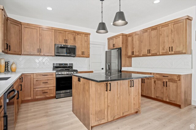 833 S 260 E, Willard, UT 84340 - kitchen with backsplash, appliances with stainless steel finishes, a kitchen island, and light wood-type flooring