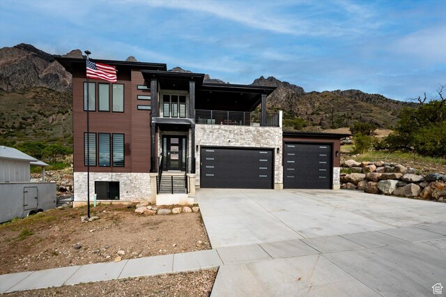 833 S 260 E, Willard, UT 84340 - contemporary home featuring stone siding, a garage, a mountain view, a balcony, and driveway
