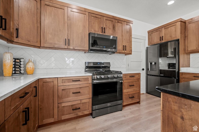 833 S 260 E, Willard, UT 84340 - kitchen featuring brown cabinetry, decorative backsplash, recessed lighting, light wood finished floors, and appliances with stainless steel finishes