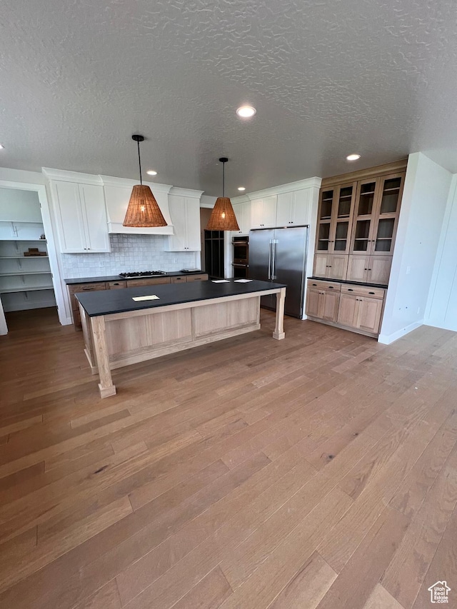 302 W Horizon View Loop Unit 35, Elk Ridge, UT 84651 - kitchen featuring a textured ceiling, dark countertops, tasteful backsplash, high quality fridge, and light wood-style flooring