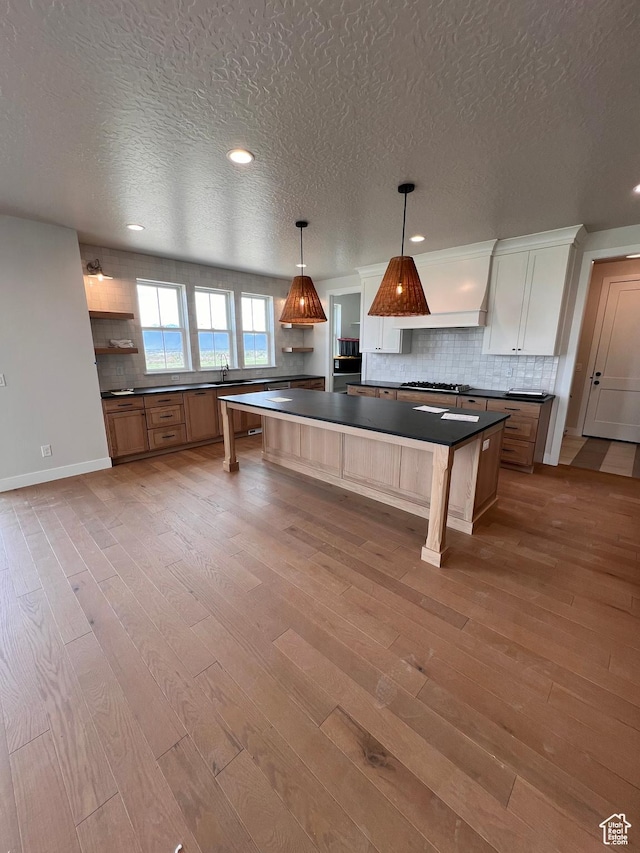 302 W Horizon View Loop Unit 35, Elk Ridge, UT 84651 - kitchen with dark countertops, backsplash, a textured ceiling, and wood finished floors