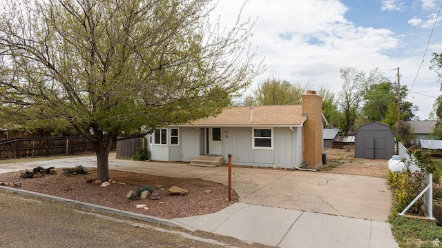 326 E 150 S, Kanab, UT 84741 - view of front of house with an outdoor structure, fence, a shed, a chimney, and driveway
