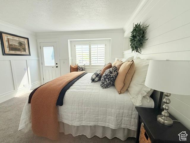 1170 N Main St, Orem, UT 84057 - bedroom with crown molding, carpet flooring, a textured ceiling, and a decorative wall
