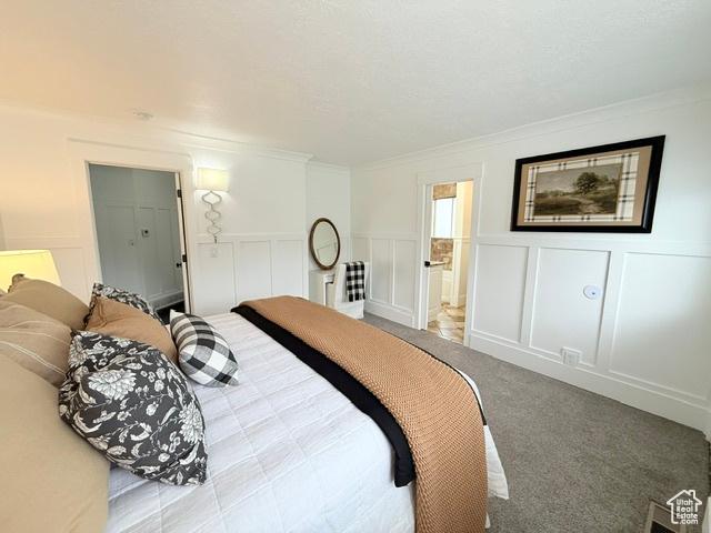 1170 N Main St, Orem, UT 84057 - bedroom featuring a decorative wall, crown molding, carpet, wainscoting, and ensuite bathroom