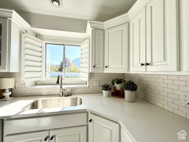 1170 N Main St, Orem, UT 84057 - kitchen with a sink, white cabinetry, light countertops, and tasteful backsplash