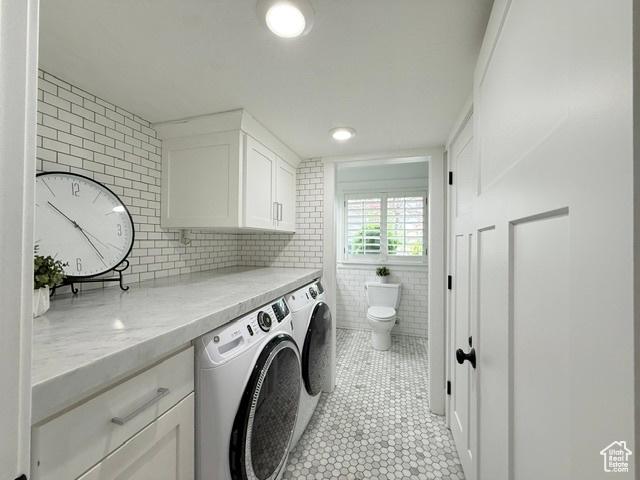 1170 N Main St, Orem, UT 84057 - laundry room with separate washer and dryer, light tile patterned flooring, cabinet space, and tile walls