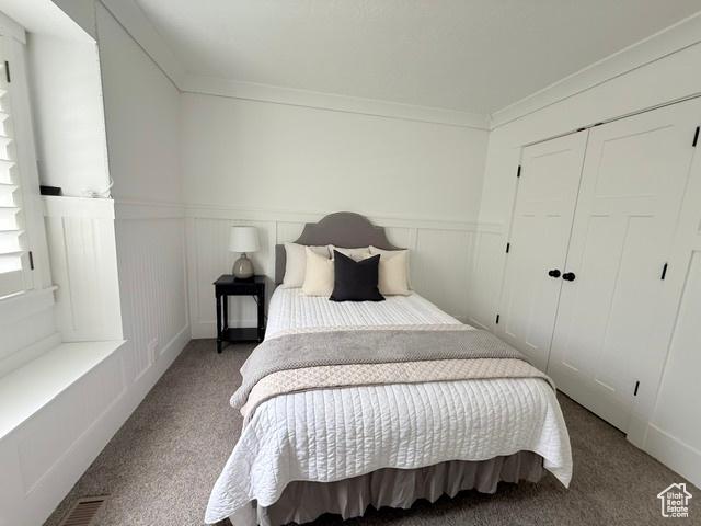 1170 N Main St, Orem, UT 84057 - carpeted bedroom with a wainscoted wall, ornamental molding, and a closet