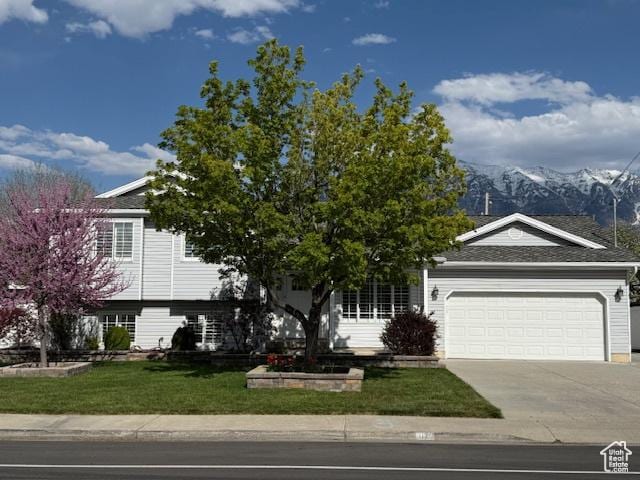 1170 N Main St, Orem, UT 84057 - view of front facade featuring an attached garage, a front lawn, a mountain view, and driveway