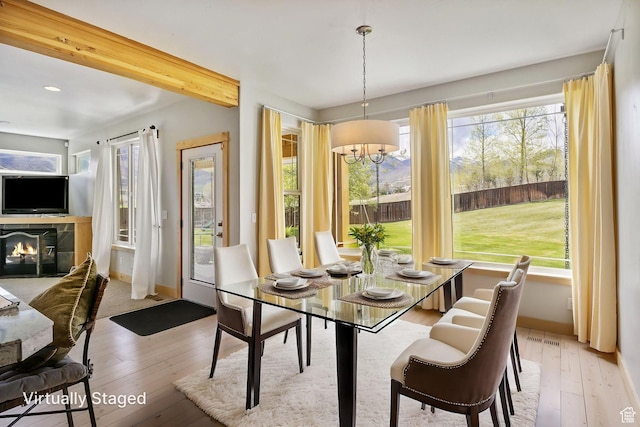 933 N Swiss Farm Ct, Midway, UT 84049 - dining room featuring light wood-style floors, a tiled fireplace, and plenty of natural light