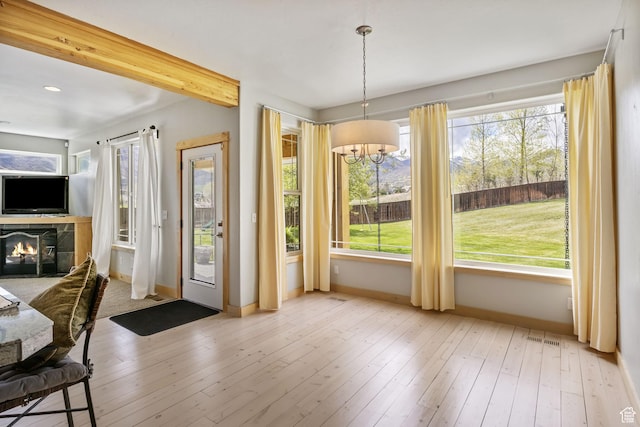 933 N Swiss Farm Ct, Midway, UT 84049 - doorway with visible vents, a tile fireplace, baseboards, an inviting chandelier, and hardwood / wood-style floors