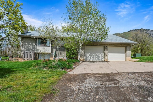 1597 E 8900 S, Paradise, UT 84328 - view of front of house with a front yard, brick siding, concrete driveway, and a mountain view