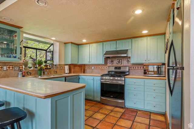 1597 E 8900 S, Paradise, UT 84328 - kitchen featuring stainless steel appliances, under cabinet range hood, a peninsula, tasteful backsplash, and a textured ceiling