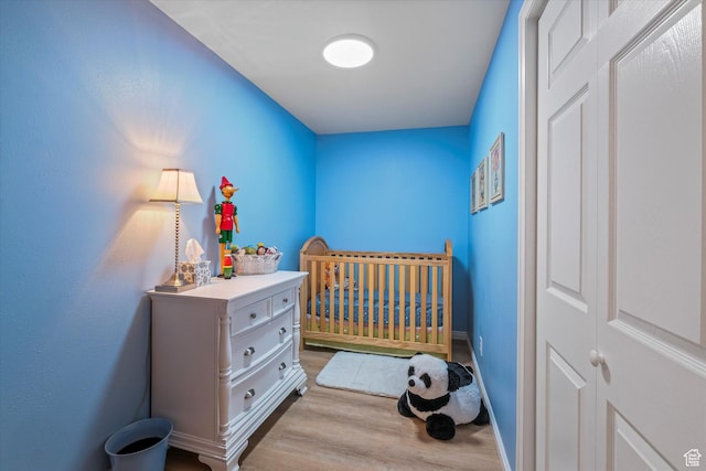 1597 E 8900 S, Paradise, UT 84328 - bedroom with light wood-style flooring, a crib, and baseboards