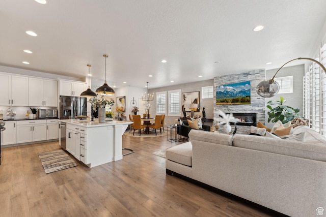 5346 W Canary Grass Way S, South Jordan, UT 84009 - living area featuring recessed lighting, a stone fireplace, and light wood-style flooring