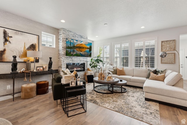 5346 W Canary Grass Way S, South Jordan, UT 84009 - living room featuring a stone fireplace, wood finished floors, plenty of natural light, and recessed lighting