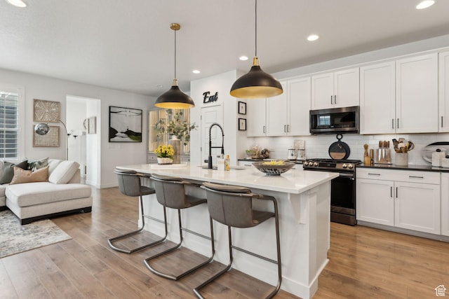 5346 W Canary Grass Way S, South Jordan, UT 84009 - kitchen featuring stainless steel gas stove, a sink, a breakfast bar, backsplash, and recessed lighting