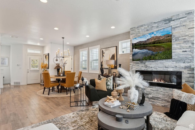 5346 W Canary Grass Way S, South Jordan, UT 84009 - living room with wood finished floors, recessed lighting, a stone fireplace, and a chandelier