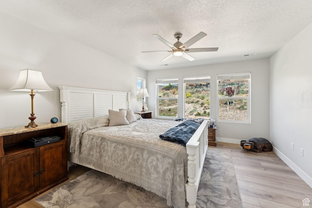 4852 N Arctic Fox Cir W Unit 2800, Lehi, UT 84043 - bedroom featuring a ceiling fan, a textured ceiling, baseboards, and light wood-type flooring