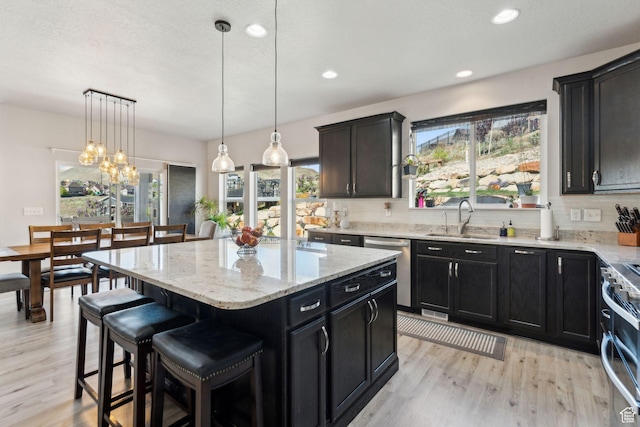 4852 N Arctic Fox Cir W Unit 2800, Lehi, UT 84043 - kitchen featuring light wood-type flooring, a sink, appliances with stainless steel finishes, and a kitchen island