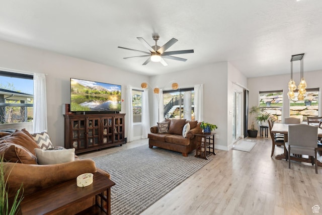 4852 N Arctic Fox Cir W Unit 2800, Lehi, UT 84043 - living room with baseboards, plenty of natural light, ceiling fan with notable chandelier, and light wood-type flooring