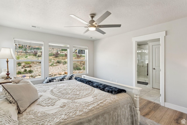 4852 N Arctic Fox Cir W Unit 2800, Lehi, UT 84043 - bedroom featuring connected bathroom, a textured ceiling, baseboards, wood finished floors, and visible vents
