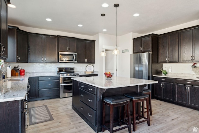 4852 N Arctic Fox Cir W Unit 2800, Lehi, UT 84043 - kitchen featuring light wood-type flooring, light stone counters, a sink, appliances with stainless steel finishes, and backsplash