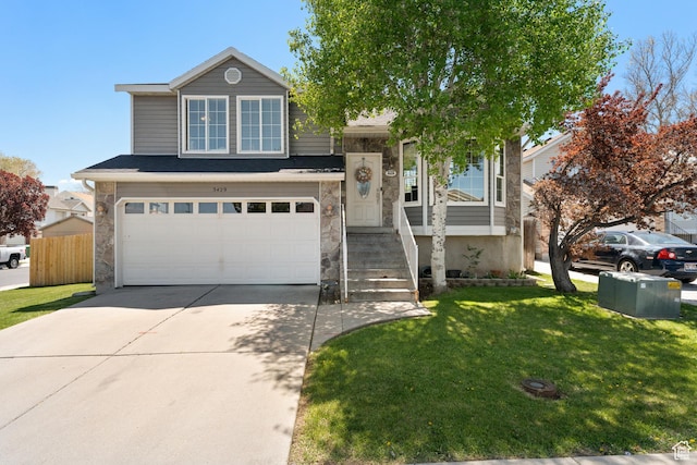 view of front of property with an attached garage, a front yard, driveway, and stone siding