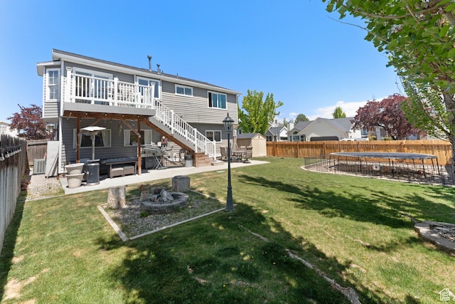 3429 W Beckford Cir, West Jordan, UT 84088 - rear view of house featuring a storage unit, a trampoline, an outdoor fire pit, a fenced backyard, and a patio area