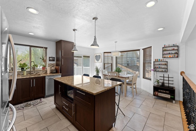 3429 W Beckford Cir, West Jordan, UT 84088 - kitchen featuring a breakfast bar area, recessed lighting, appliances with stainless steel finishes, and dark brown cabinets