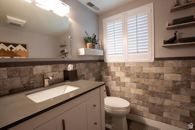 5716 S Maplewood Dr E, South Ogden, UT 84405 - bathroom with visible vents, vanity, toilet, tile walls, and a wainscoted wall