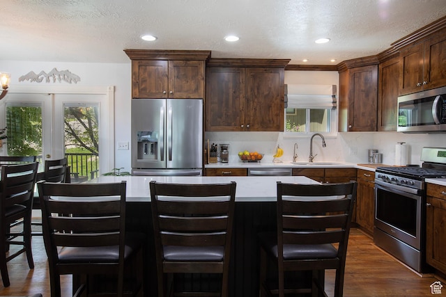 5716 S Maplewood Dr E, South Ogden, UT 84405 - kitchen featuring a sink, light countertops, stainless steel appliances, decorative backsplash, and dark wood-type flooring