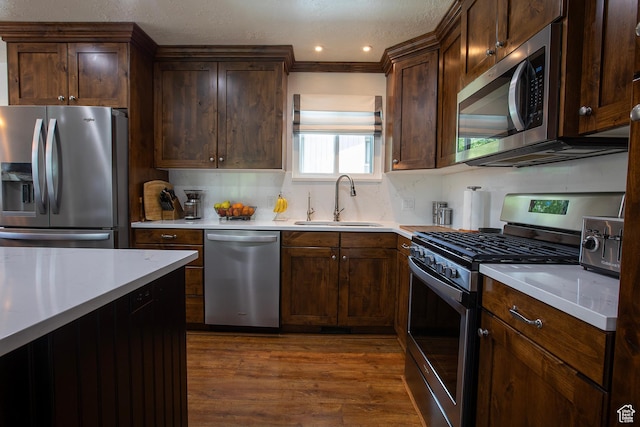 5716 S Maplewood Dr E, South Ogden, UT 84405 - kitchen featuring appliances with stainless steel finishes, a sink, light countertops, tasteful backsplash, and dark wood-style floors