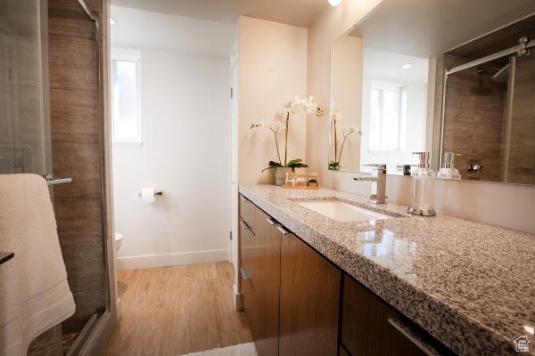 2812 E Commonwealth Ave S, Salt Lake City, UT 84109 - bathroom featuring baseboards, a shower stall, wood finished floors, and vanity