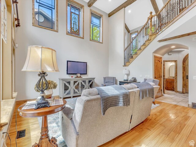 14099 S Pine Mesa Dr, Draper, UT 84020 - living area featuring visible vents, a towering ceiling, arched walkways, stairway, and wood-type flooring