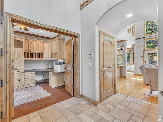 14099 S Pine Mesa Dr, Draper, UT 84020 - interior space featuring a ceiling fan, a towering ceiling, baseboards, arched walkways, and light wood-style flooring