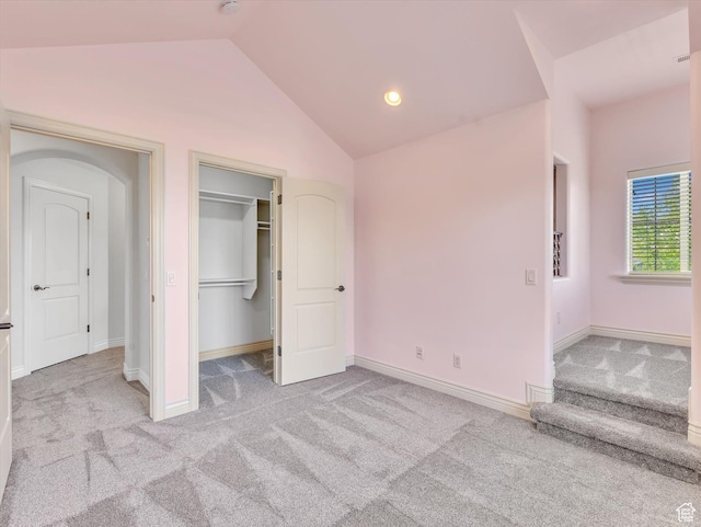 14099 S Pine Mesa Dr, Draper, UT 84020 - unfurnished bedroom featuring a walk in closet, arched walkways, baseboards, lofted ceiling, and carpet
