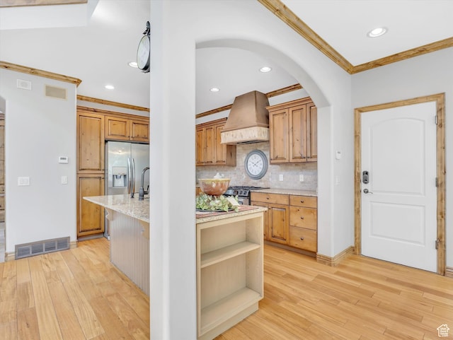 14099 S Pine Mesa Dr, Draper, UT 84020 - kitchen featuring light wood-style flooring, stainless steel appliances, custom range hood, visible vents, and ornamental molding