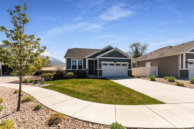 craftsman house with fence, a front lawn, a garage, board and batten siding, and driveway