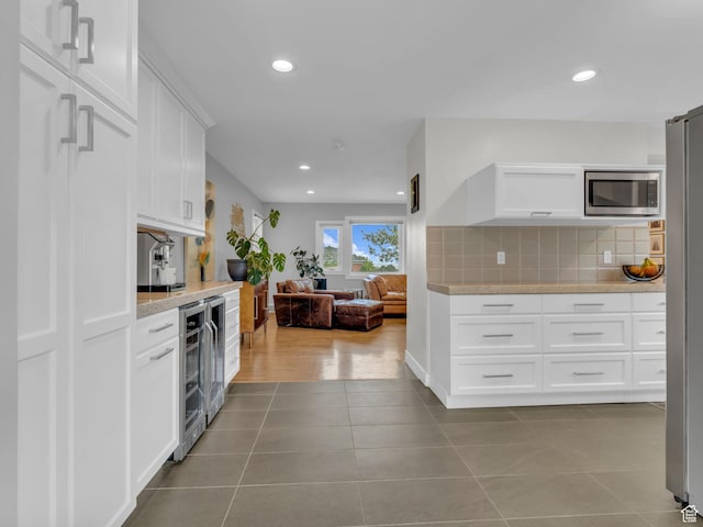 3133 S 2700 E, Millcreek, UT 84109 - kitchen with white cabinets, appliances with stainless steel finishes, tile patterned flooring, beverage cooler, and tasteful backsplash