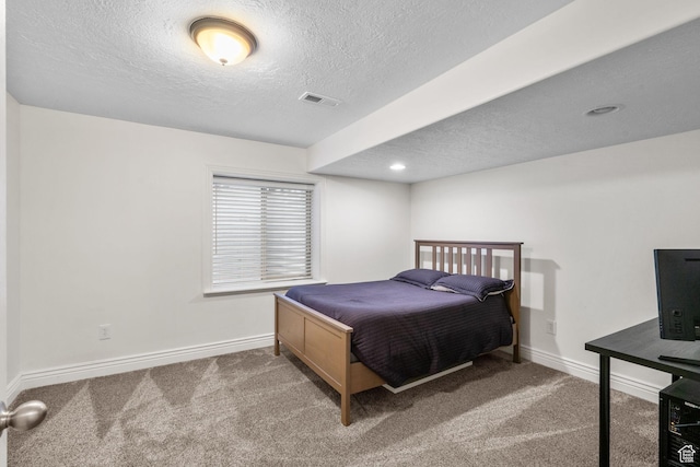 carpeted bedroom with baseboards, a textured ceiling, and visible vents