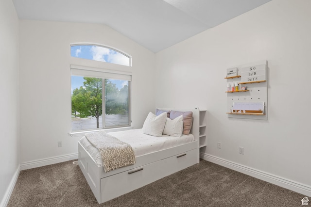 bedroom featuring dark carpet, baseboards, and lofted ceiling