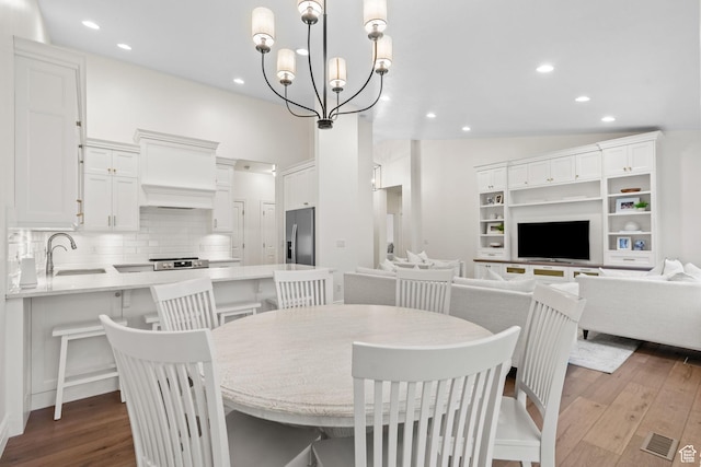 dining room with recessed lighting, a chandelier, dark wood-style floors, and vaulted ceiling
