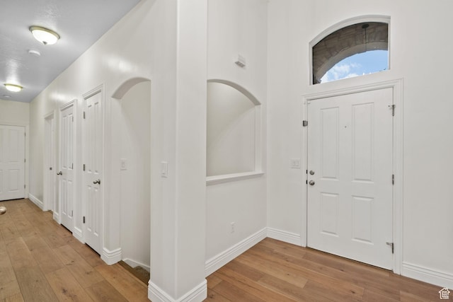 entryway with wood-type flooring and baseboards