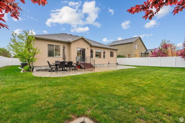 rear view of house with a lawn, a fenced backyard, a patio area, and stucco siding