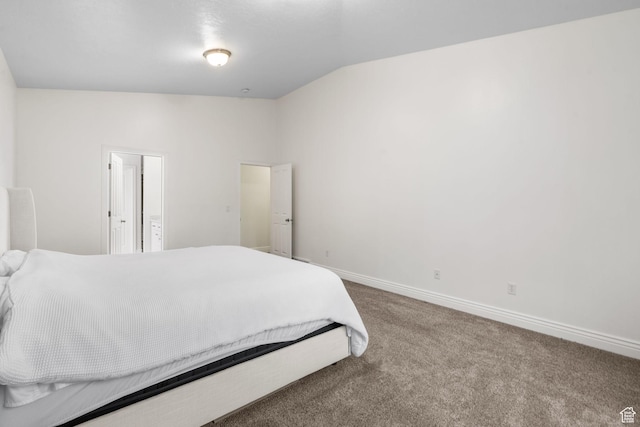 carpeted bedroom featuring baseboards and vaulted ceiling