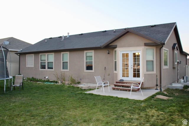 512 Stone Way, Santaquin, UT 84655 - rear view of house with a trampoline, stucco siding, a patio area, french doors, and a lawn