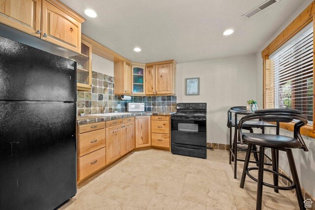 288 S Hillside Dr E, Elk Ridge, UT 84651 - kitchen with decorative backsplash, visible vents, black appliances, glass insert cabinets, and tile counters
