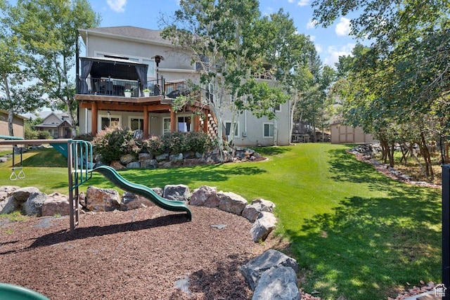 288 S Hillside Dr E, Elk Ridge, UT 84651 - rear view of house featuring a yard, a deck, a playground, and stucco siding