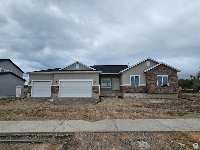 ranch-style home with a garage, stone siding, and stucco siding