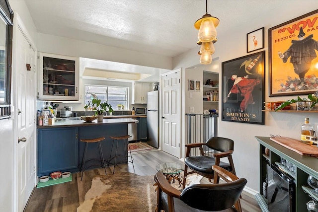 interior space with a textured ceiling and wood finished floors